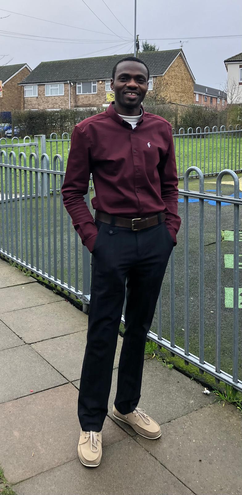 Pastor Samuel Yakubu smiling in a burgundy shirt outdoors